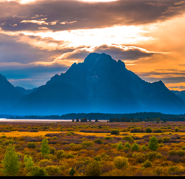 a landscape with mountains in the background; Grand Tetons