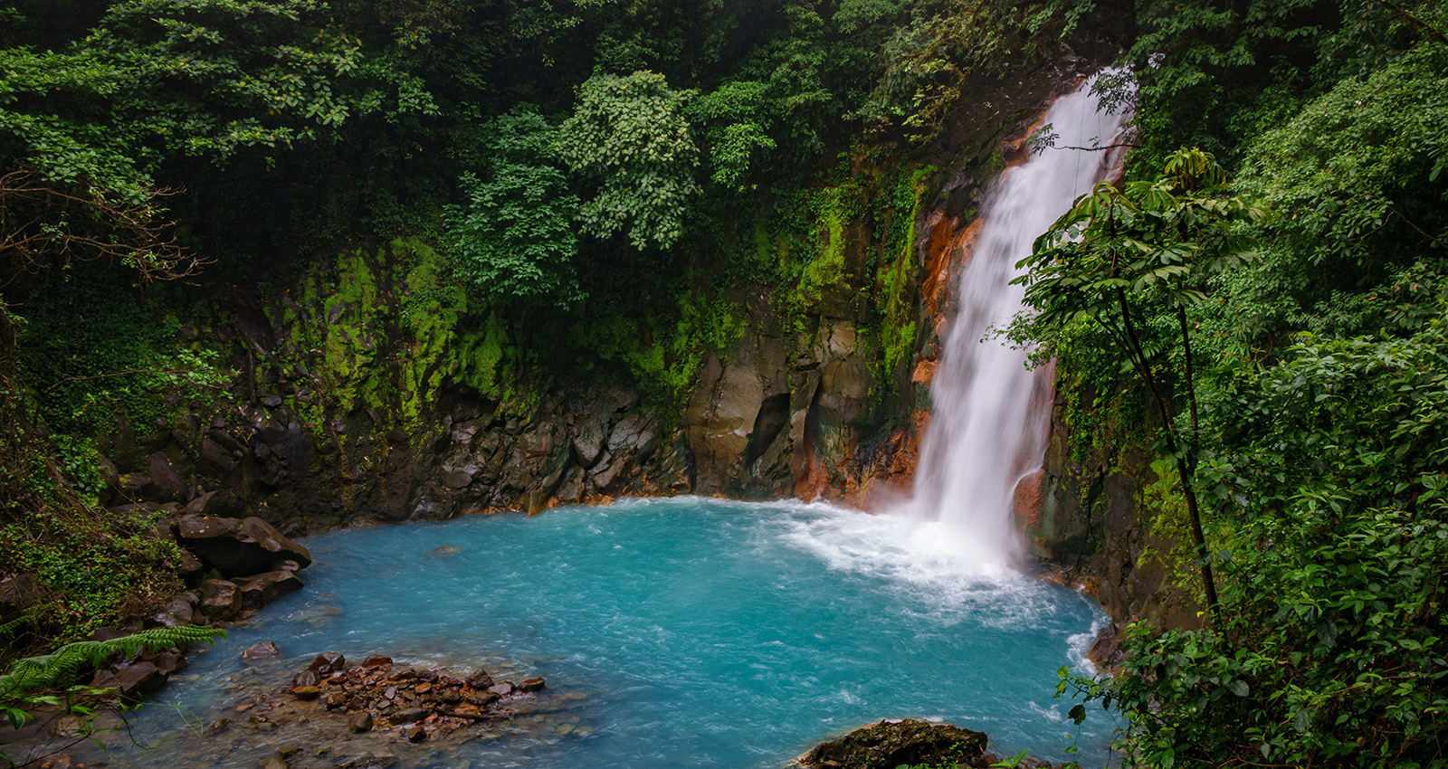 Celestial blue waterfall and pond in volcan tenorio national park Celeste River in a forest Tenorio National Park Costa Rica