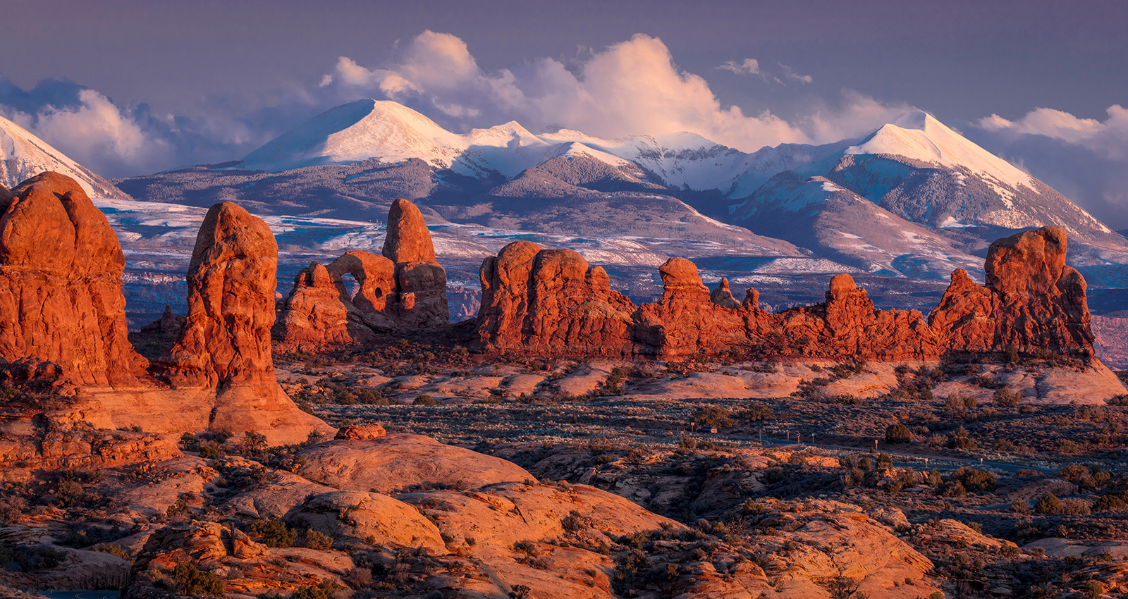Arches National Park, Utah at sunset with LaSalle snowcapped Mountains in distant view - winter a landscape with mountains in the background with Arches National Park in the background